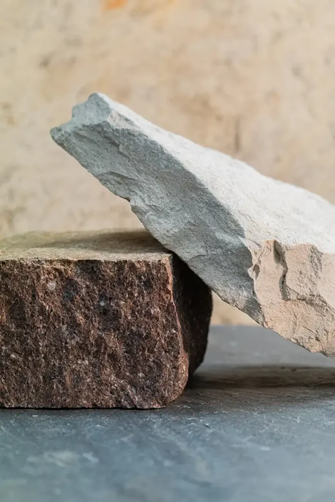 Blocs de pedra natural tallada apilats amb tonalitats grises i marrons rogenques, Construccions Ramilo