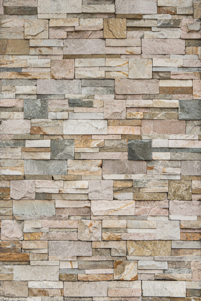 Panell de pedra natural Quarsita Fina amb peces allargades i rectangulars de mides diverses, tons beix, grisos clars i verdosos suaus, textura fina i vetes discretes, per a revestiments i façanes lluminoses i atemporals — Construccions Ramilo