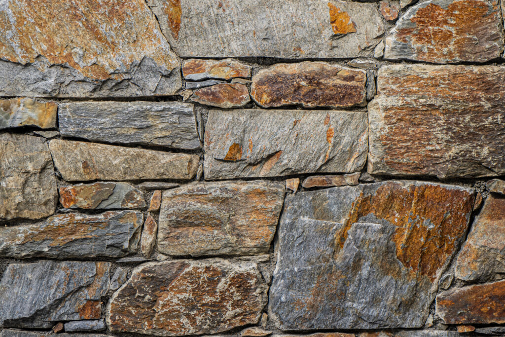 Mur de pedra artesana natural Nicorella amb peces irregulars, tons grisos amb matisos ocres i marrons i textura rústica, per a façanes i murs d'accent, Construccions Ramilo