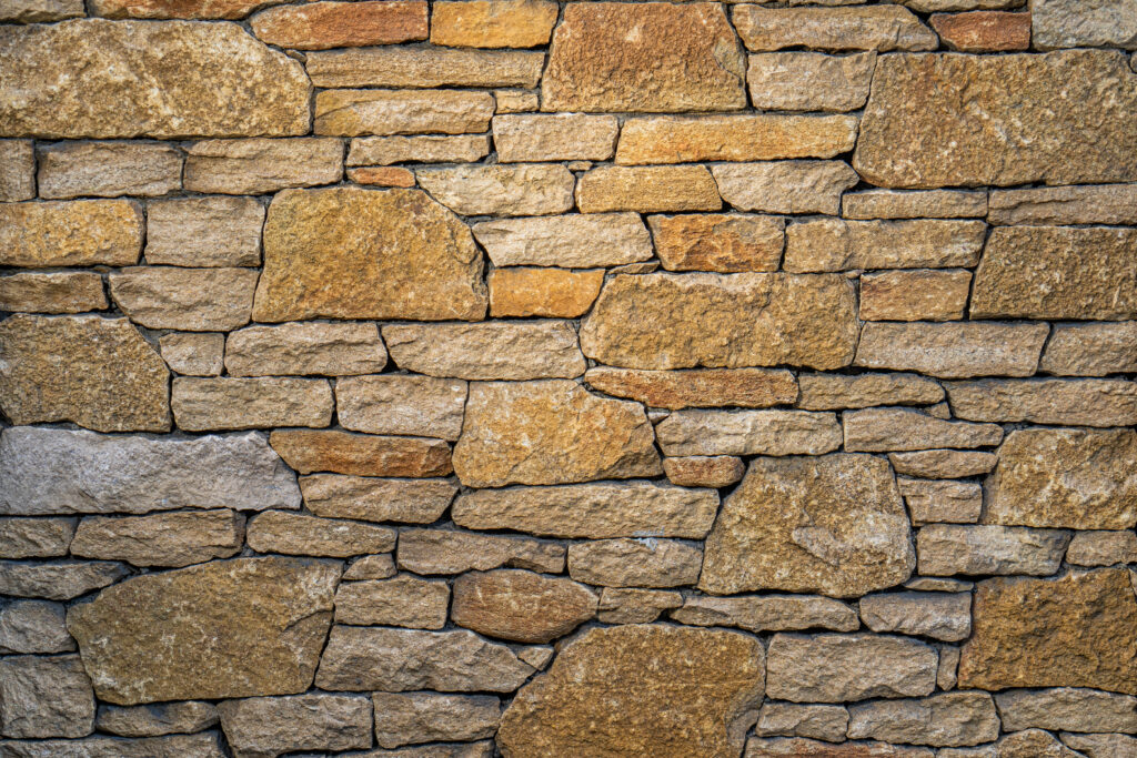 Mur de pedra artesana natural Yellow amb tonalitats grogues i daurades càlides, peces irregulars i textura natural, per a murs d'accent, Construccions Ramilo
