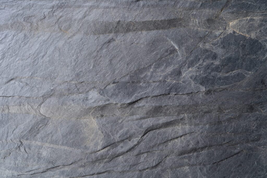 Mur de revestiment de pissarra natural National Rústica amb peces irregulars, superfície de tall rústic i tonalitats grises fosques, Construccions Ramilo